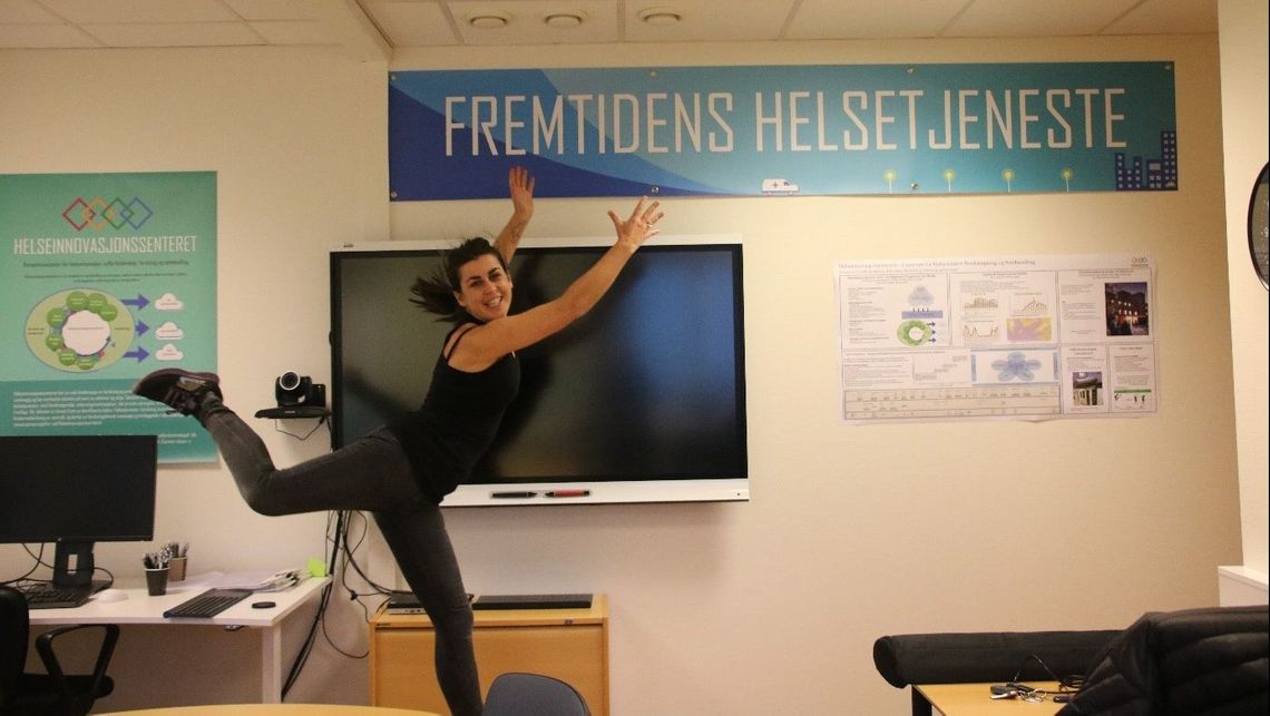 Fride viser frem plakat "fremtidens helsetjeneste"