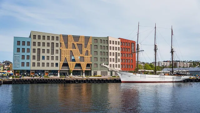 Campus Kristiansund fasade ved vannet, med stort hvitt treskip utenfor